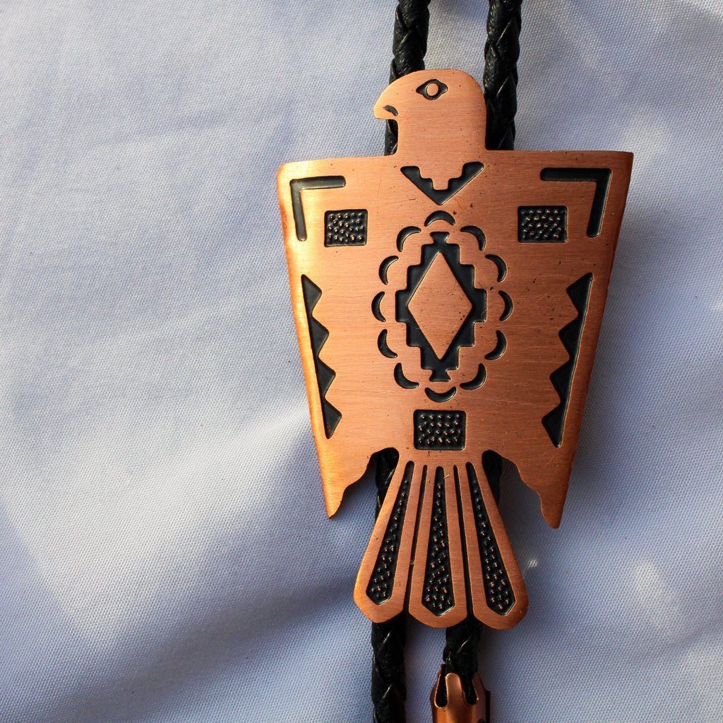 Copper thunderbird bolo tie tips and braided cord detail