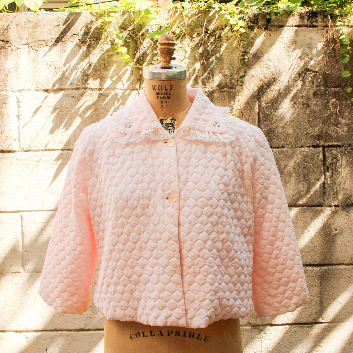 70s pink quilted bed jacket - front view on dress form
