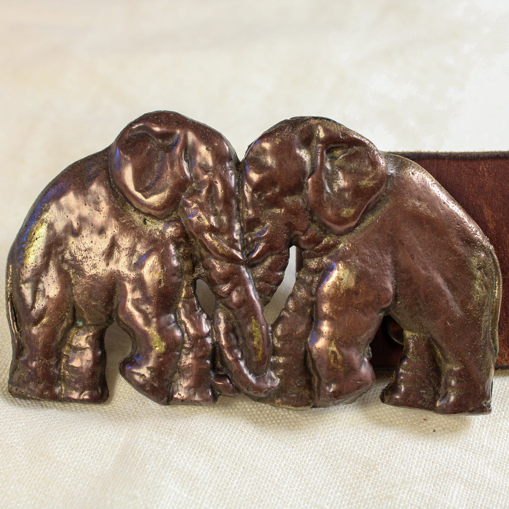 Front view on surface, elephant brass buckle