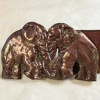 Front view on surface, elephant brass buckle