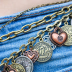 Close up of 90s mixed metal coin charm chain belt on denim