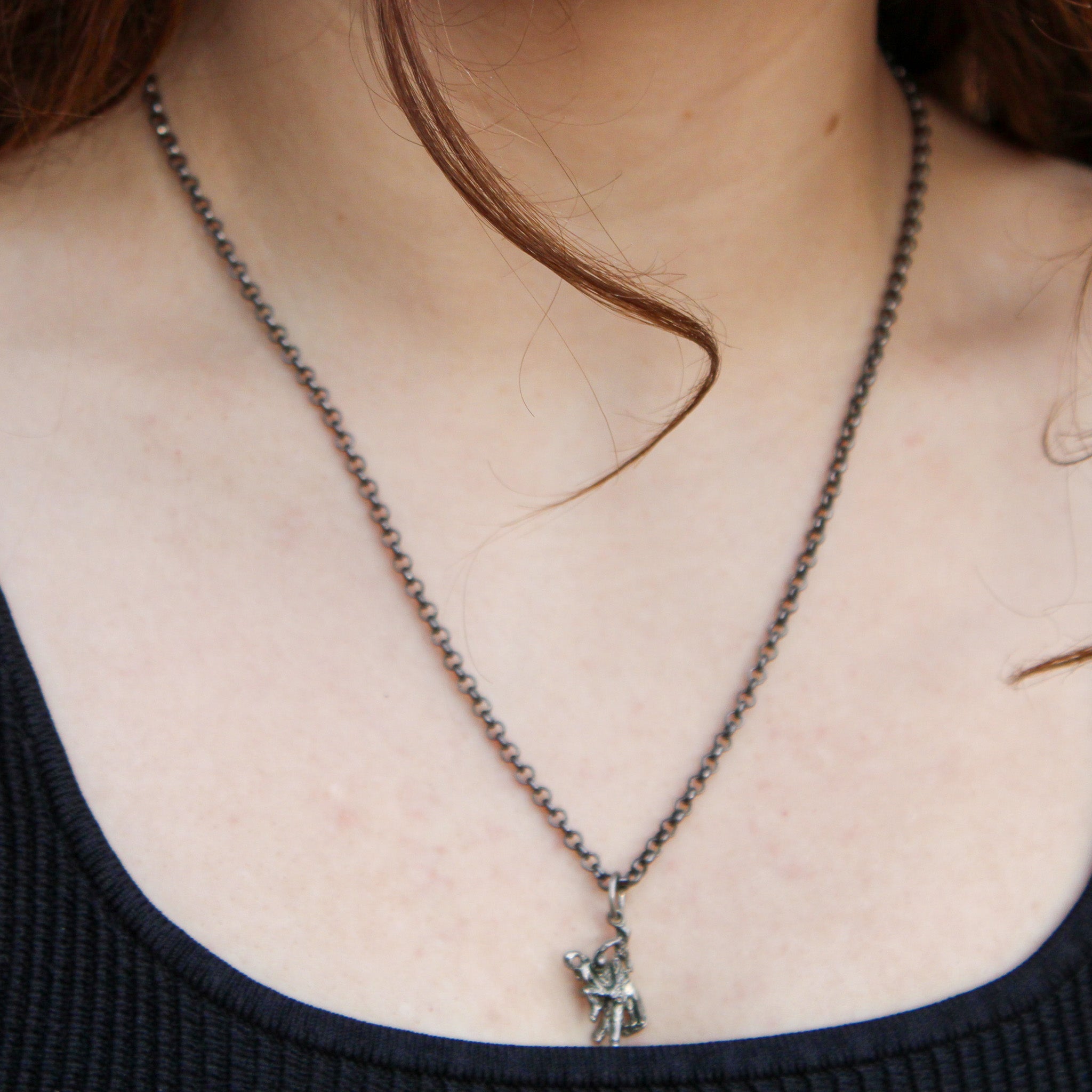 Front view of abstract cowboy pendant necklace