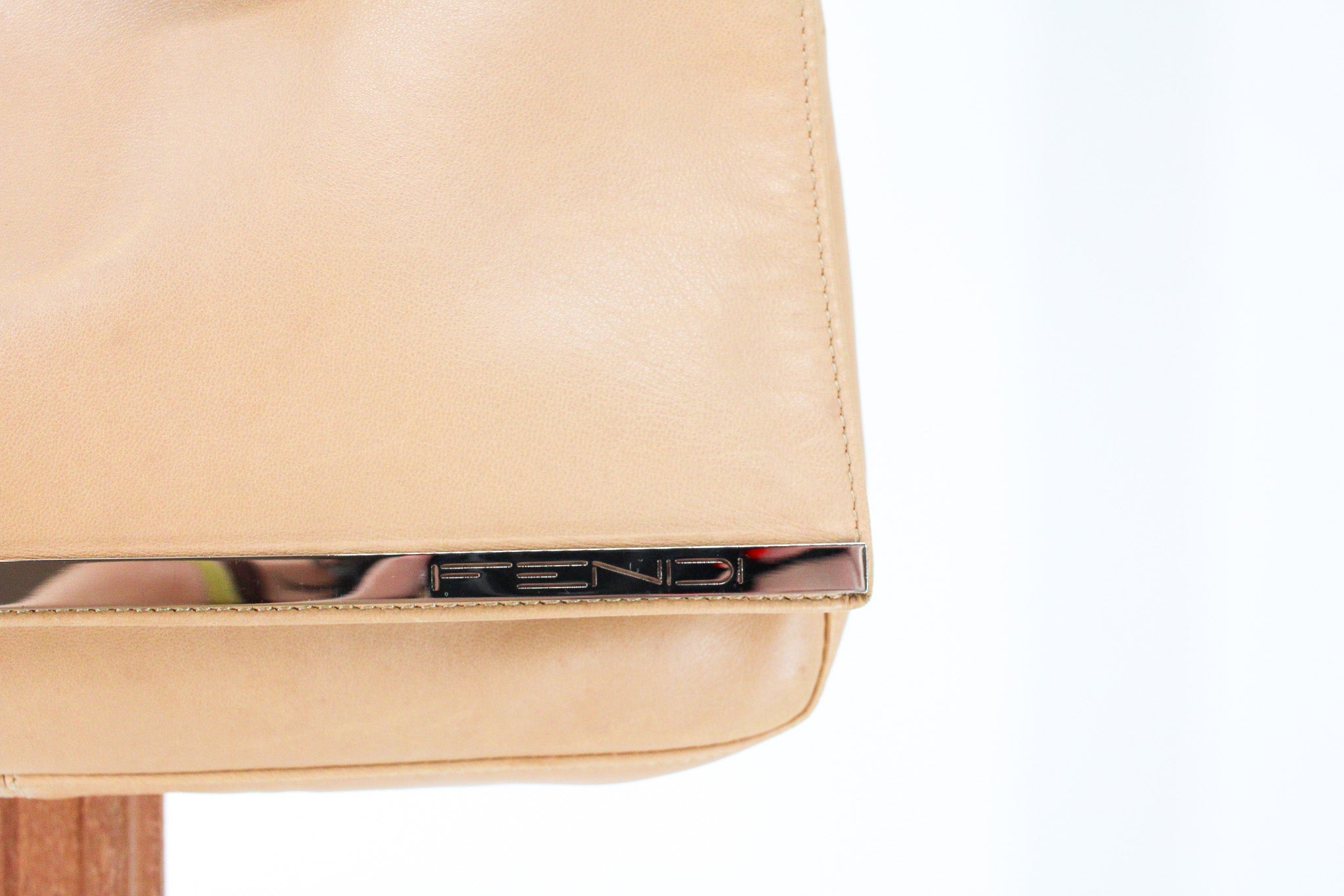 silver metal bar spelling fendi on the front flap
