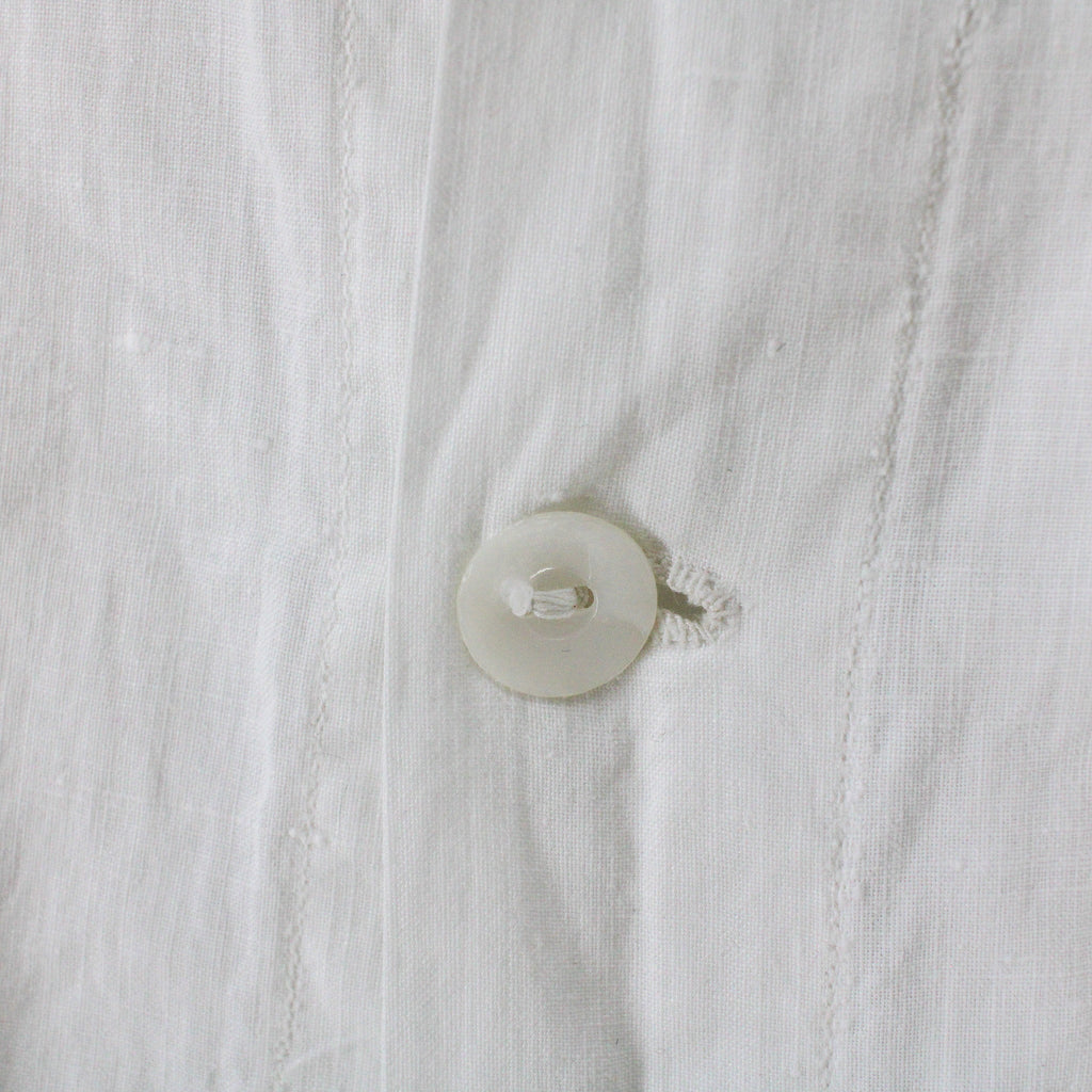 mother-of-pearl placket button and hand-worked buttonhole