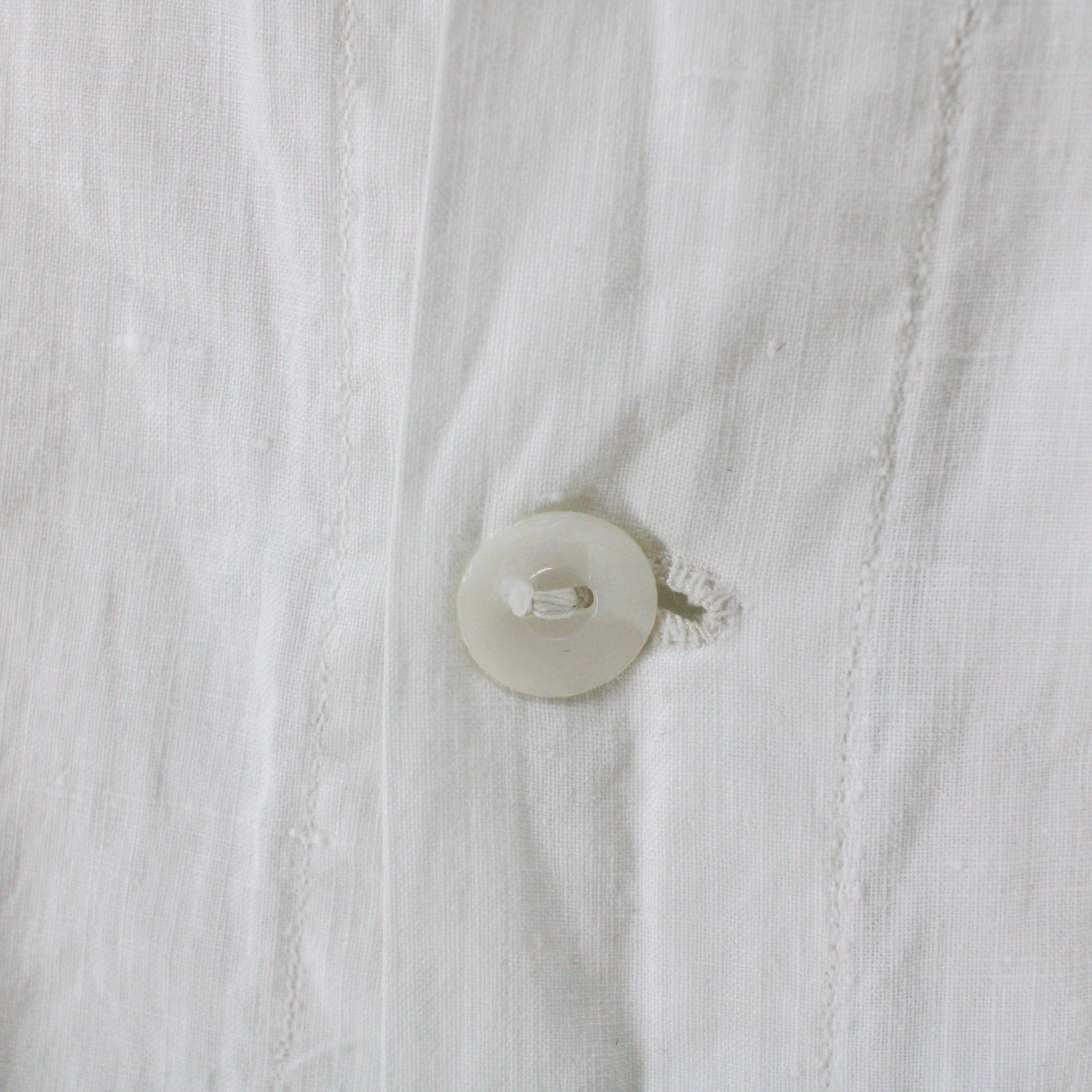 mother-of-pearl placket button and hand-worked buttonhole