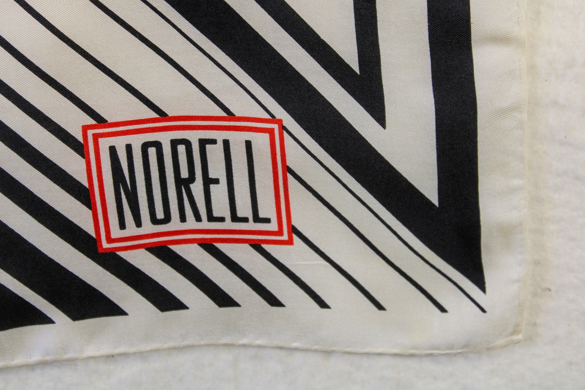 vintage norman norell “n” graphic silk scarf – black & white with red logo