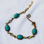 Flat lay of 60s 70s faux turquoise cabochon bracelet with safety chain